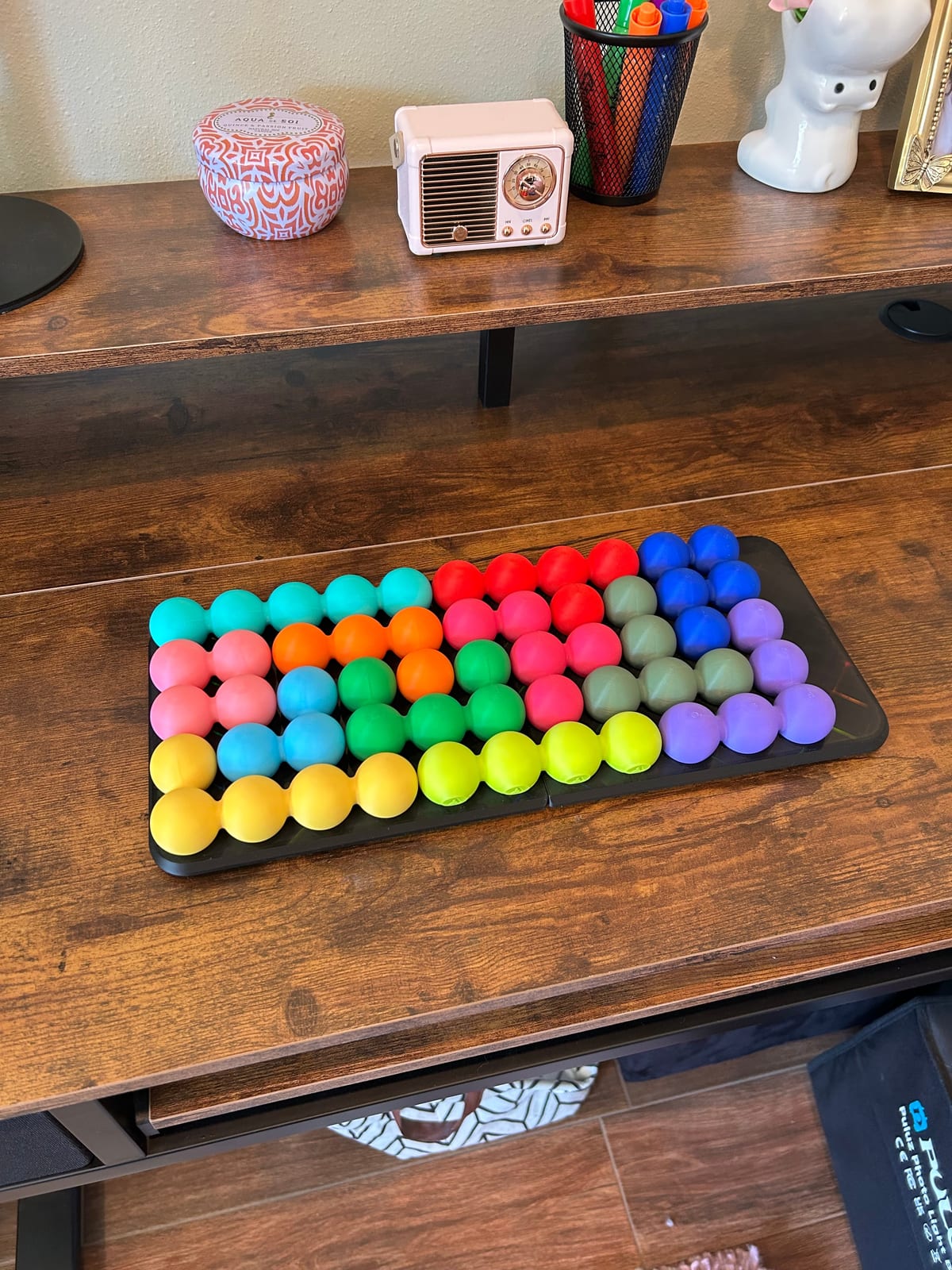 Katachi-Go's colorful sphere-cluster pieces filling the tray on a desk